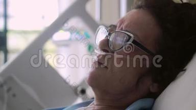 一位戴眼镜的老年妇女被关在一张病床上，上面滴着氧气罩。 4k. 3840x2160